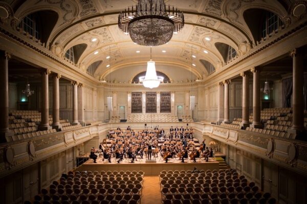 Groot symfonieorkest speelt in een rijk versierde concertzaal